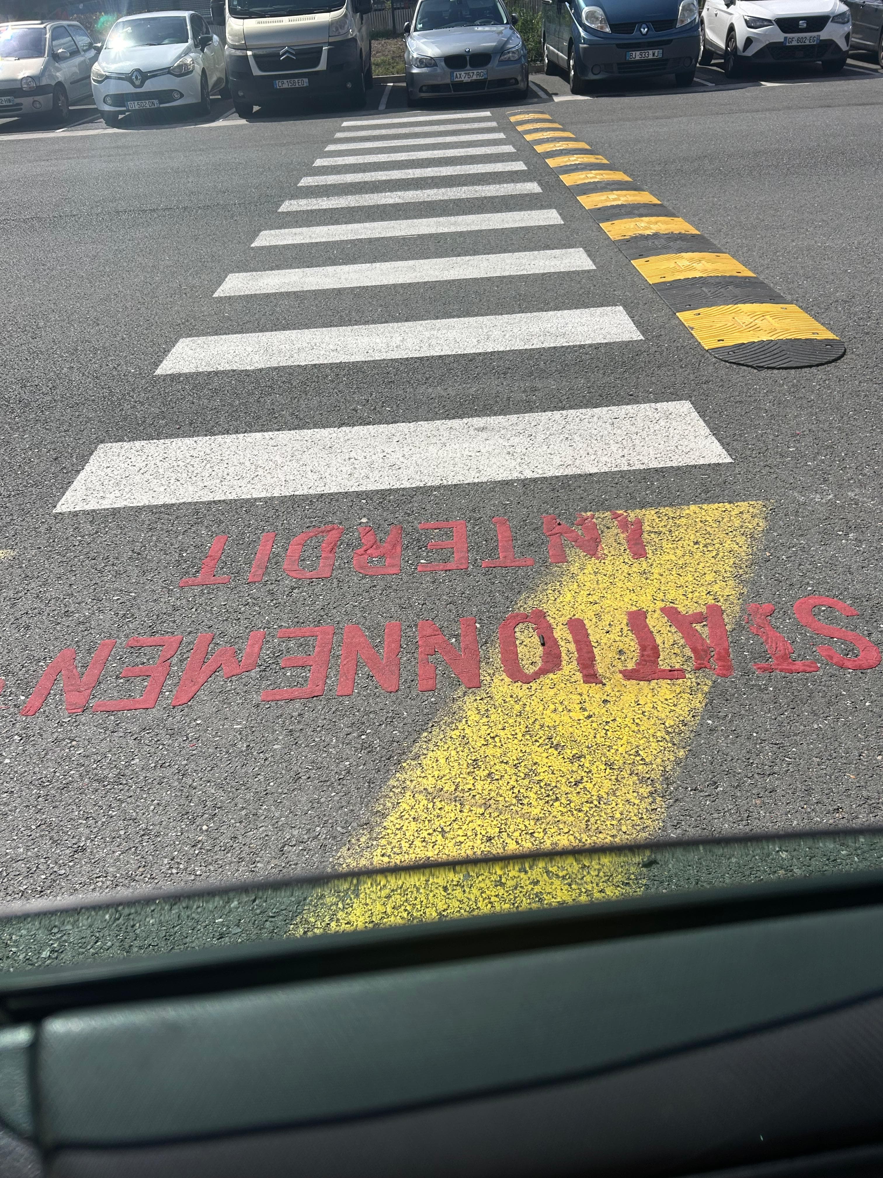 Passage piéton et dos d'âne fraîchement marqués sur un parking - Aurès Construction