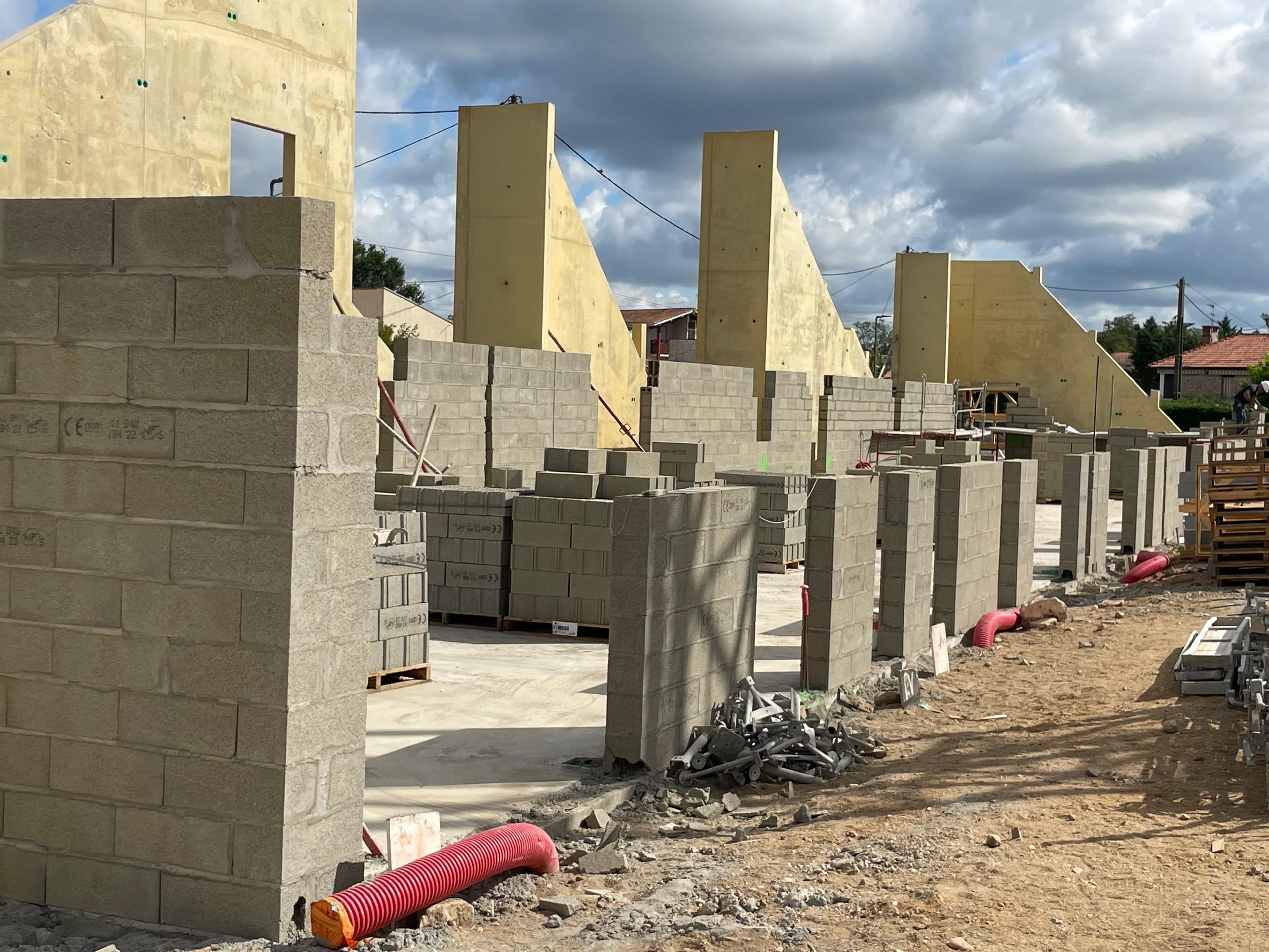 Montage de murs en parpaing sur un chantier de bâtiment professionnel - Aurès Construction