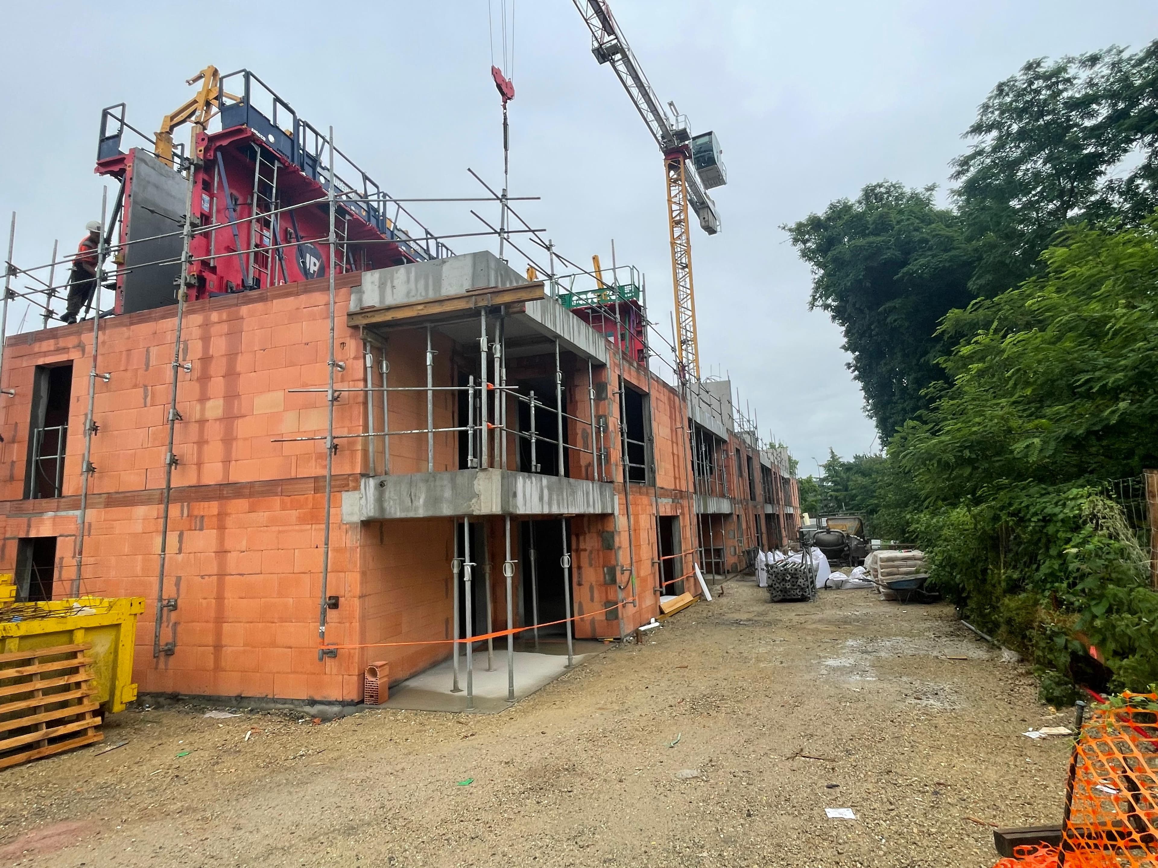 Montage des murs en briques et échafaudage sur un chantier de logements - Aurès Construction