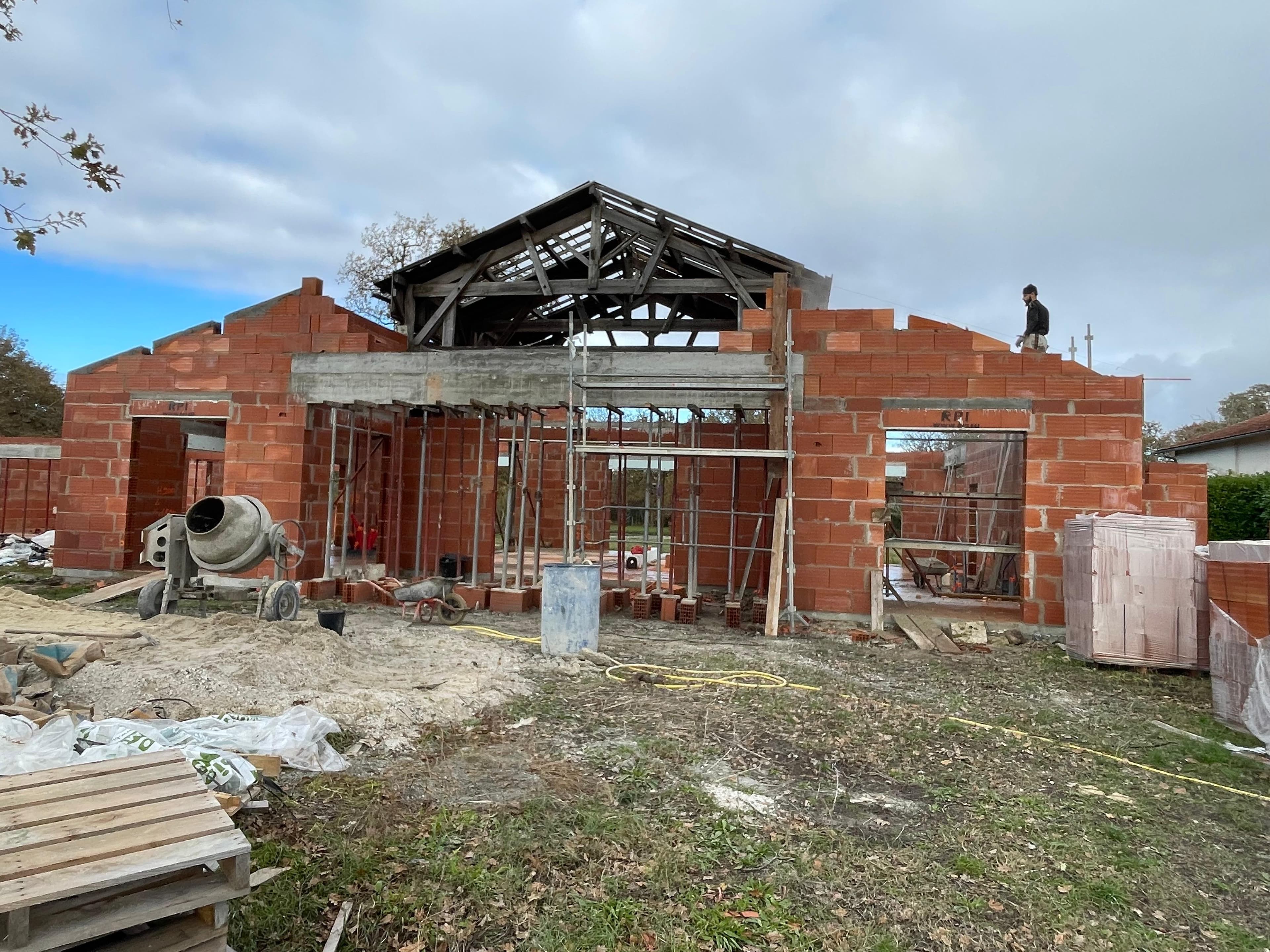 Charpente en bois posée sur une élévation en briques avant couverture - Aurès Construction