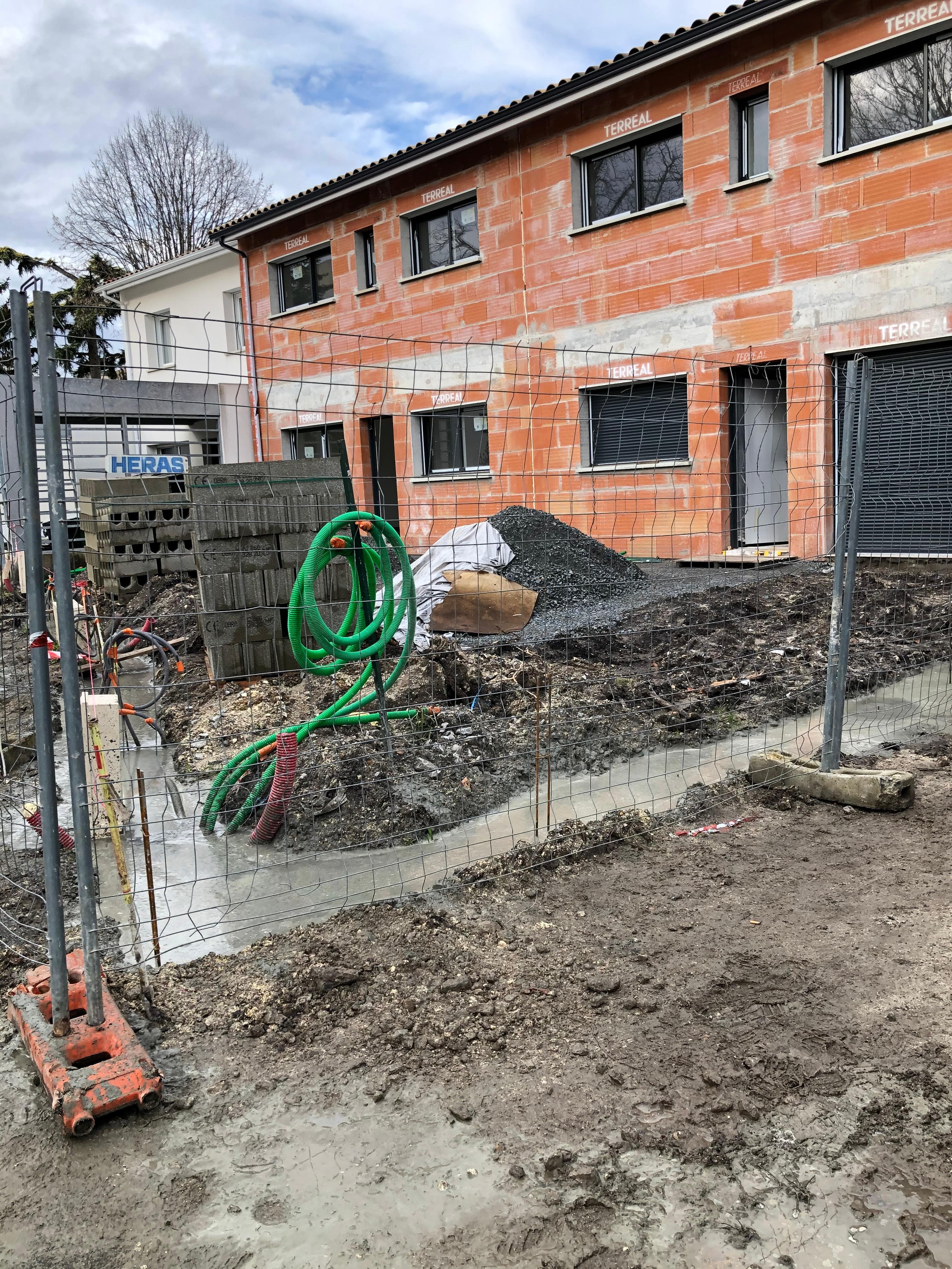 Façade en briques terminée avec fenêtres posées - Aurès Construction
