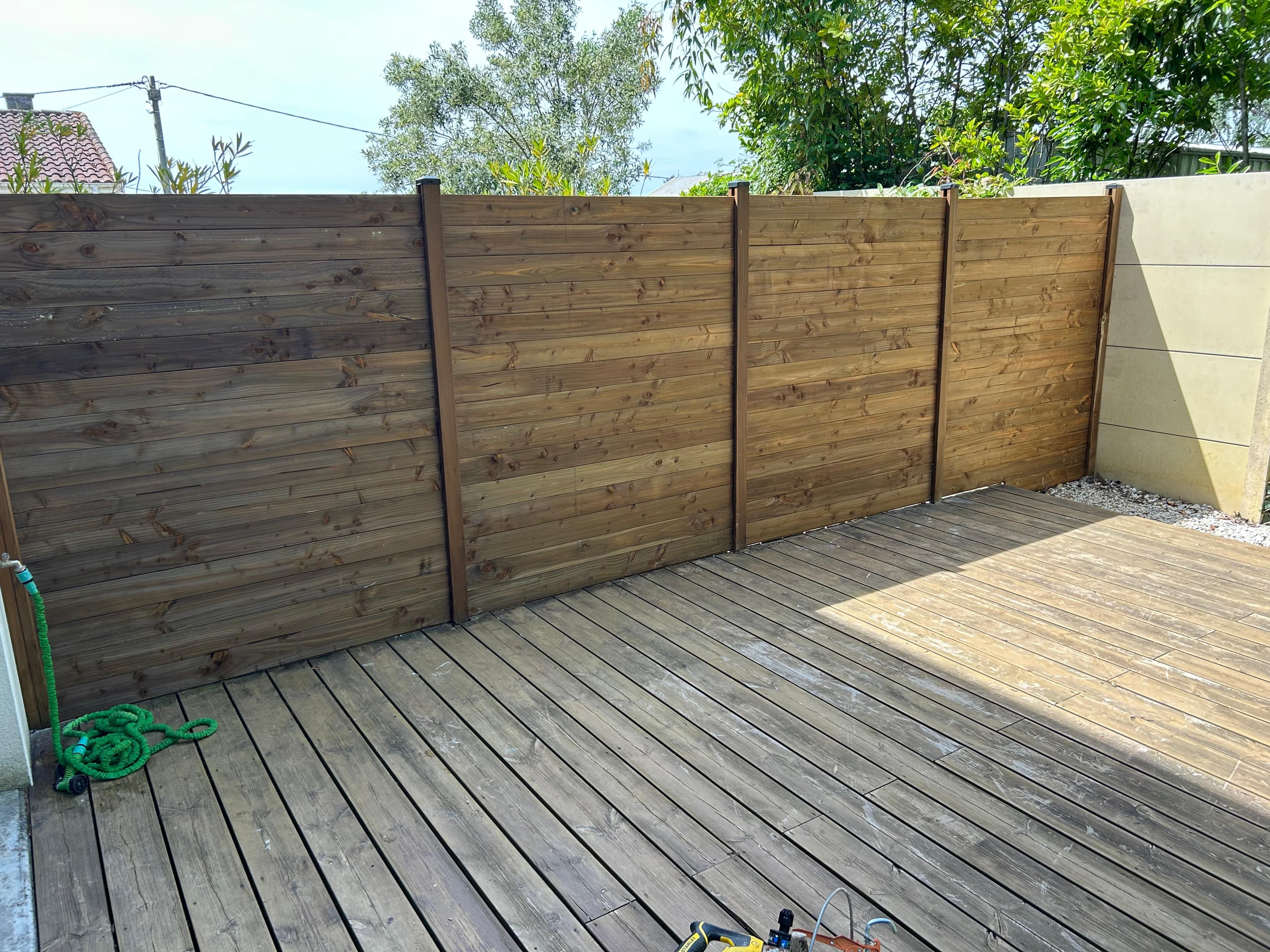 Terrasse en bois et clôture en lames de bois livrées - Aurès Construction